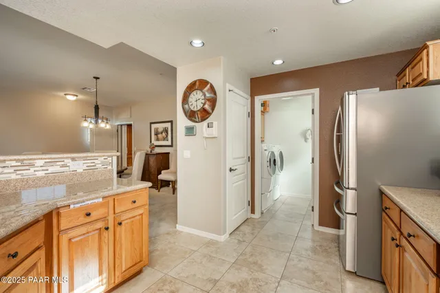 a kitchen with stainless steel appliances granite countertop a refrigerator and a stove top oven