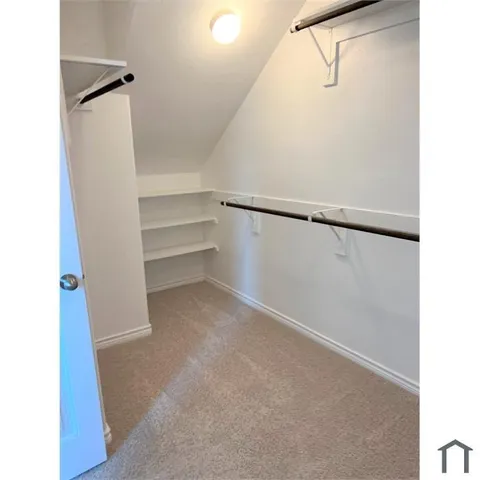 a view of walk in closet with empty racks