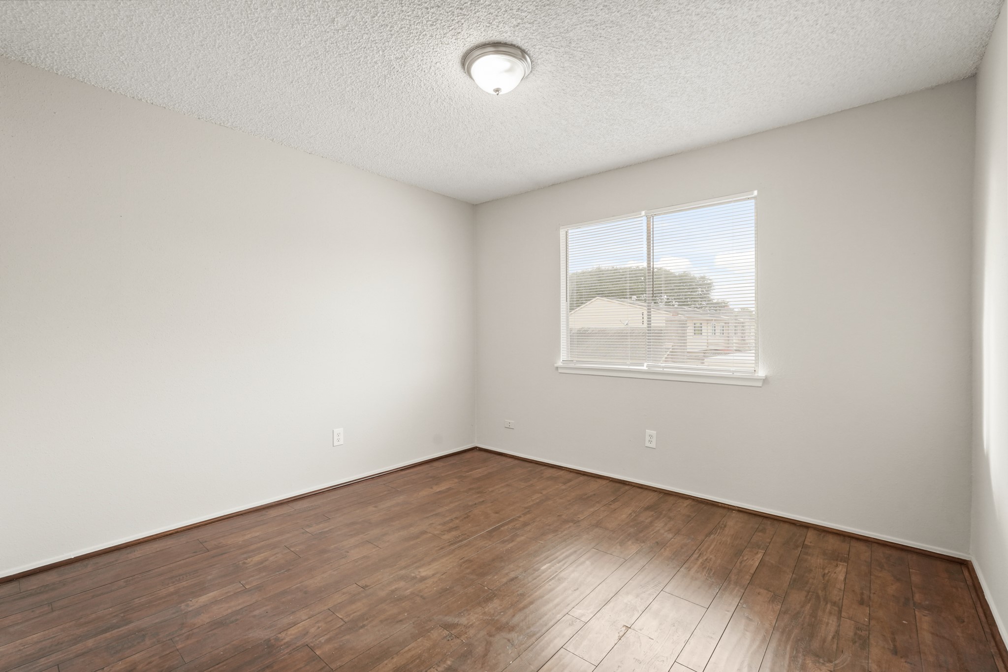 10328 Cook Road Houston, TX 77099 - Photo 6 of 16 an empty room with wooden floor and windows
