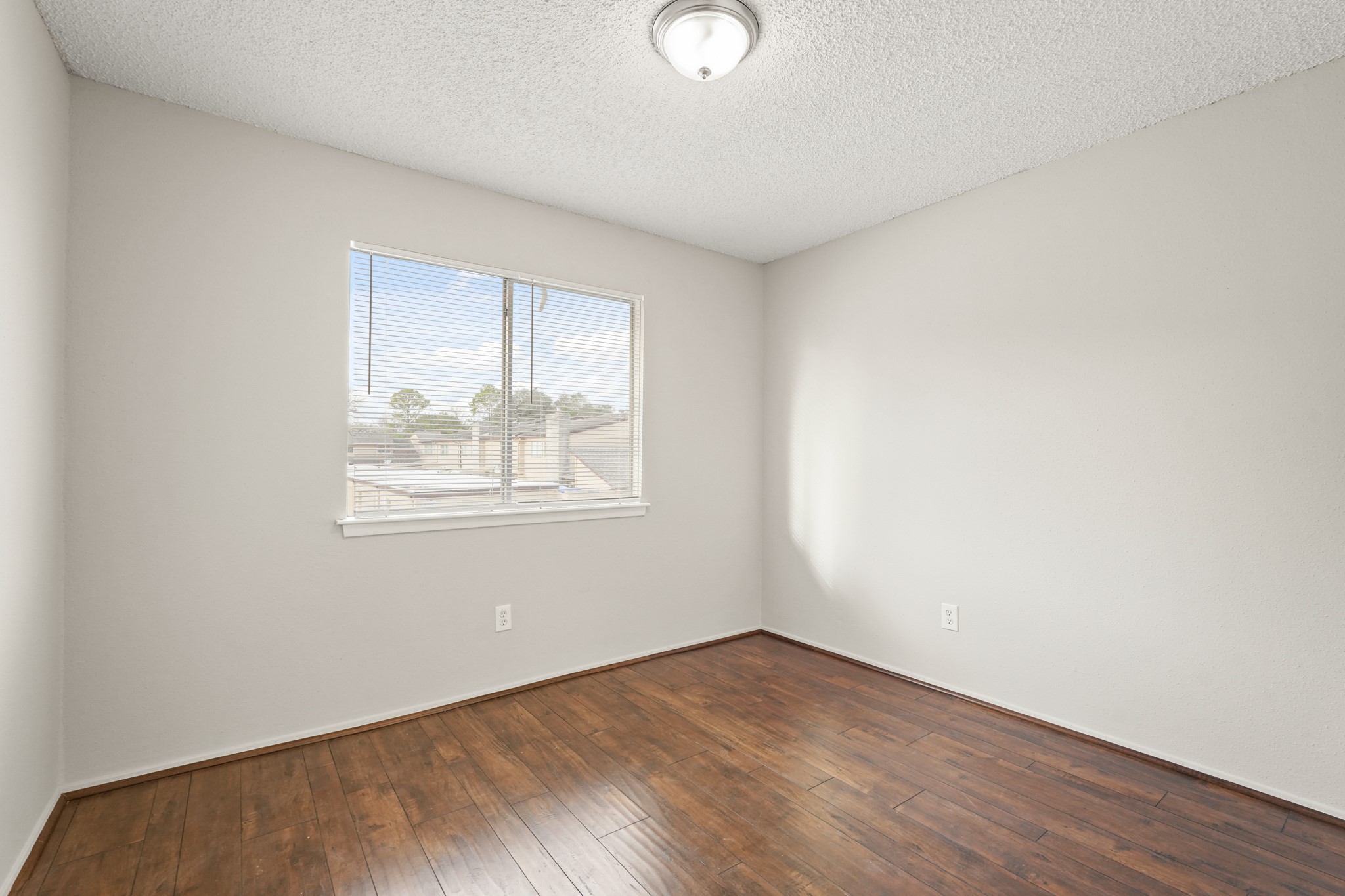 10328 Cook Road Houston, TX 77099 - Photo 7 of 16 an empty room with wooden floor and windows