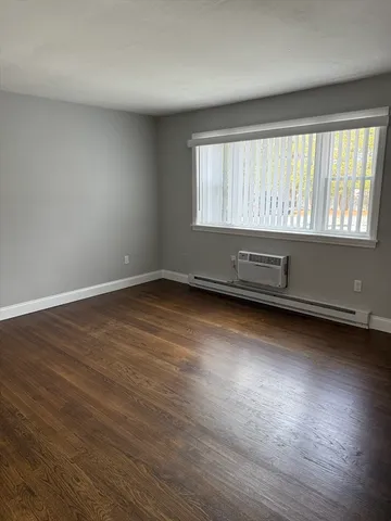 a view of room with window and wooden floor