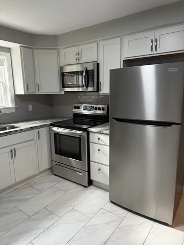 a kitchen with white cabinets and stainless steel appliances