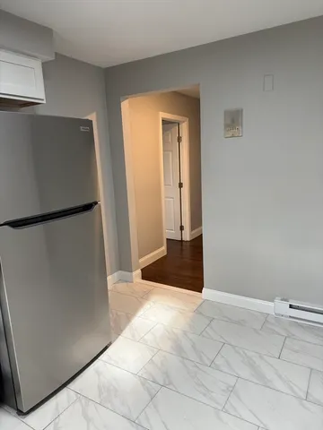 a view of a kitchen with a refrigerator and cabinet in it