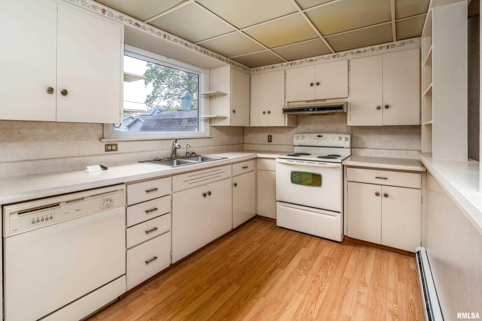 2120 Logan Street Murphysboro, IL 62966 - Photo 11 of 30 a kitchen with cabinets oven a sink and dishwasher with wooden floor