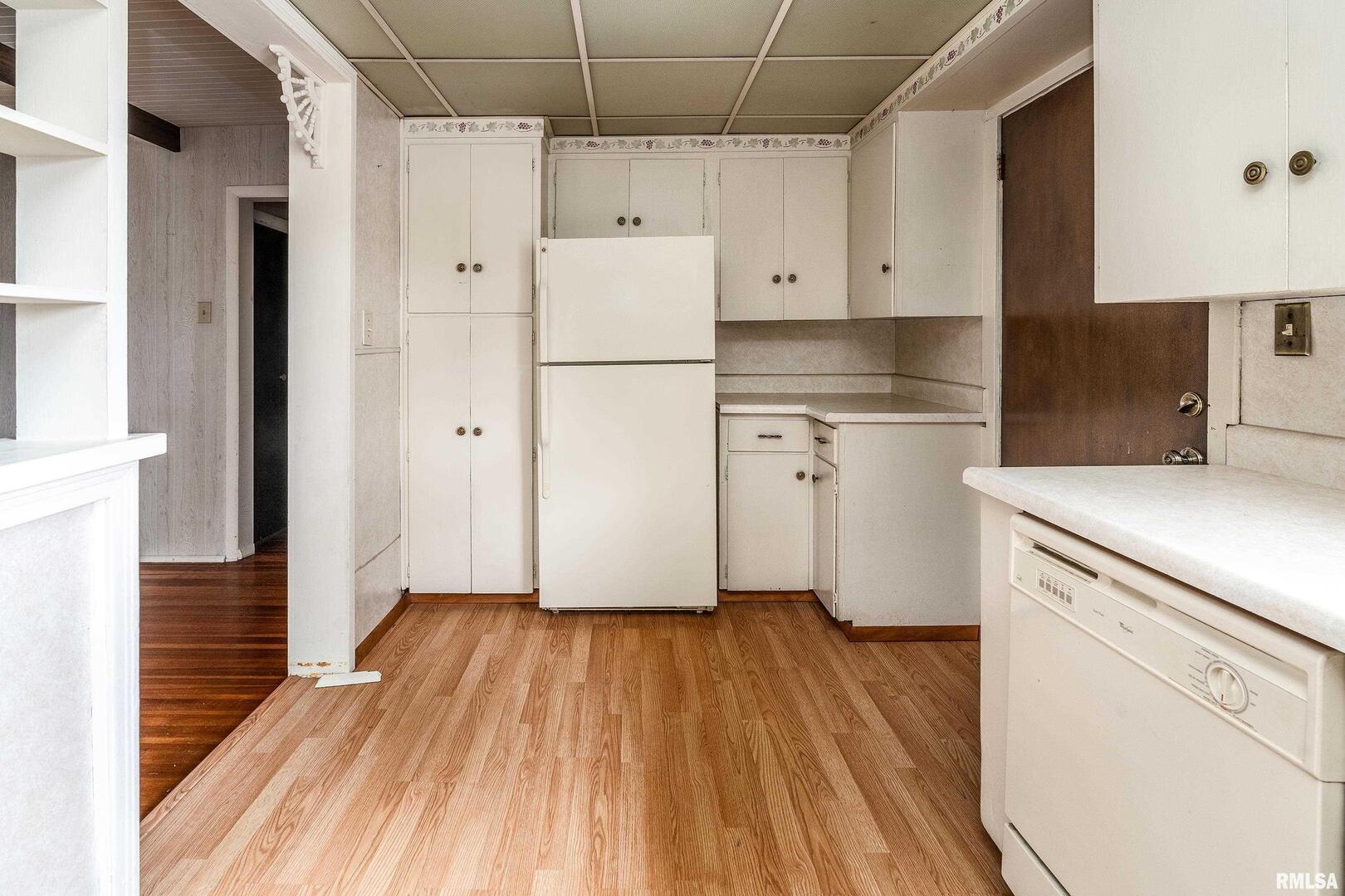 2120 Logan Street Murphysboro, IL 62966 - Photo 13 of 30 a kitchen with wooden floors and white appliances