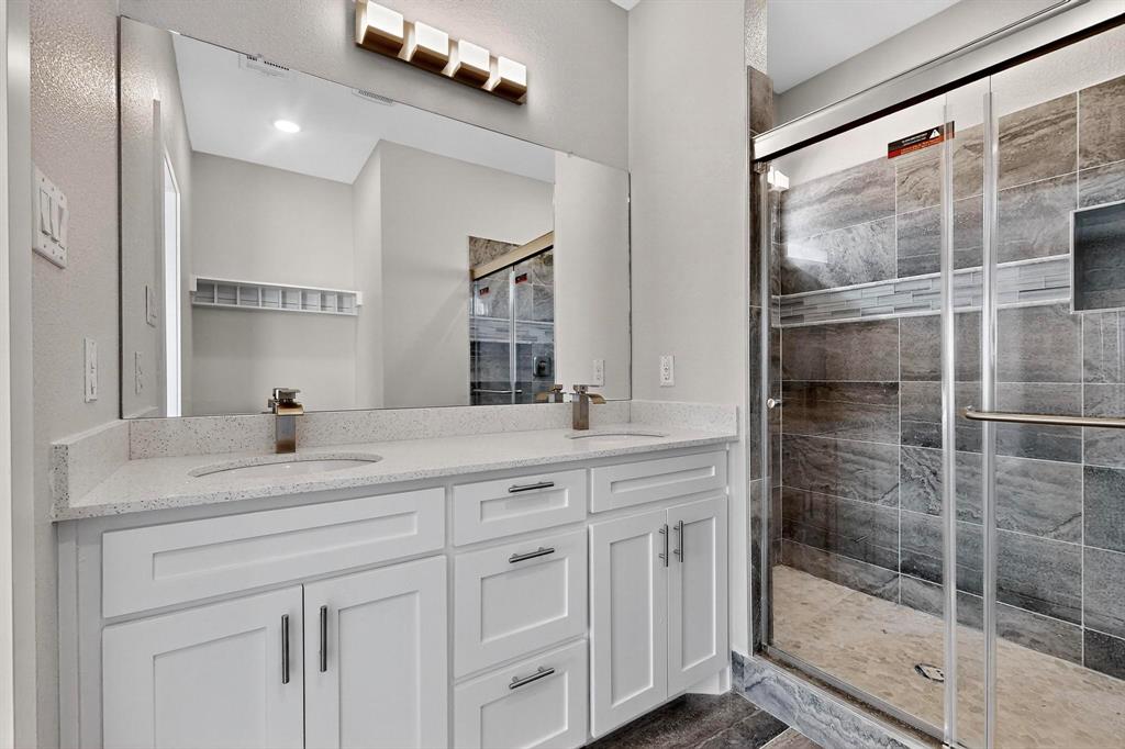 740 Section House Road Ennis, TX 75119 - Photo 20 of 31 a bathroom with a granite countertop sink a mirror and shower