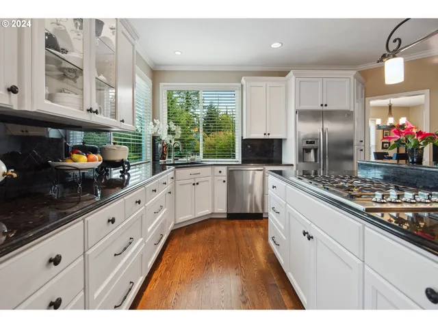 a kitchen with stainless steel appliances granite countertop a sink stove and refrigerator