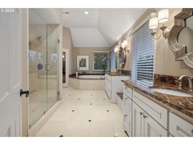 a bathroom with a tub sink and mirror