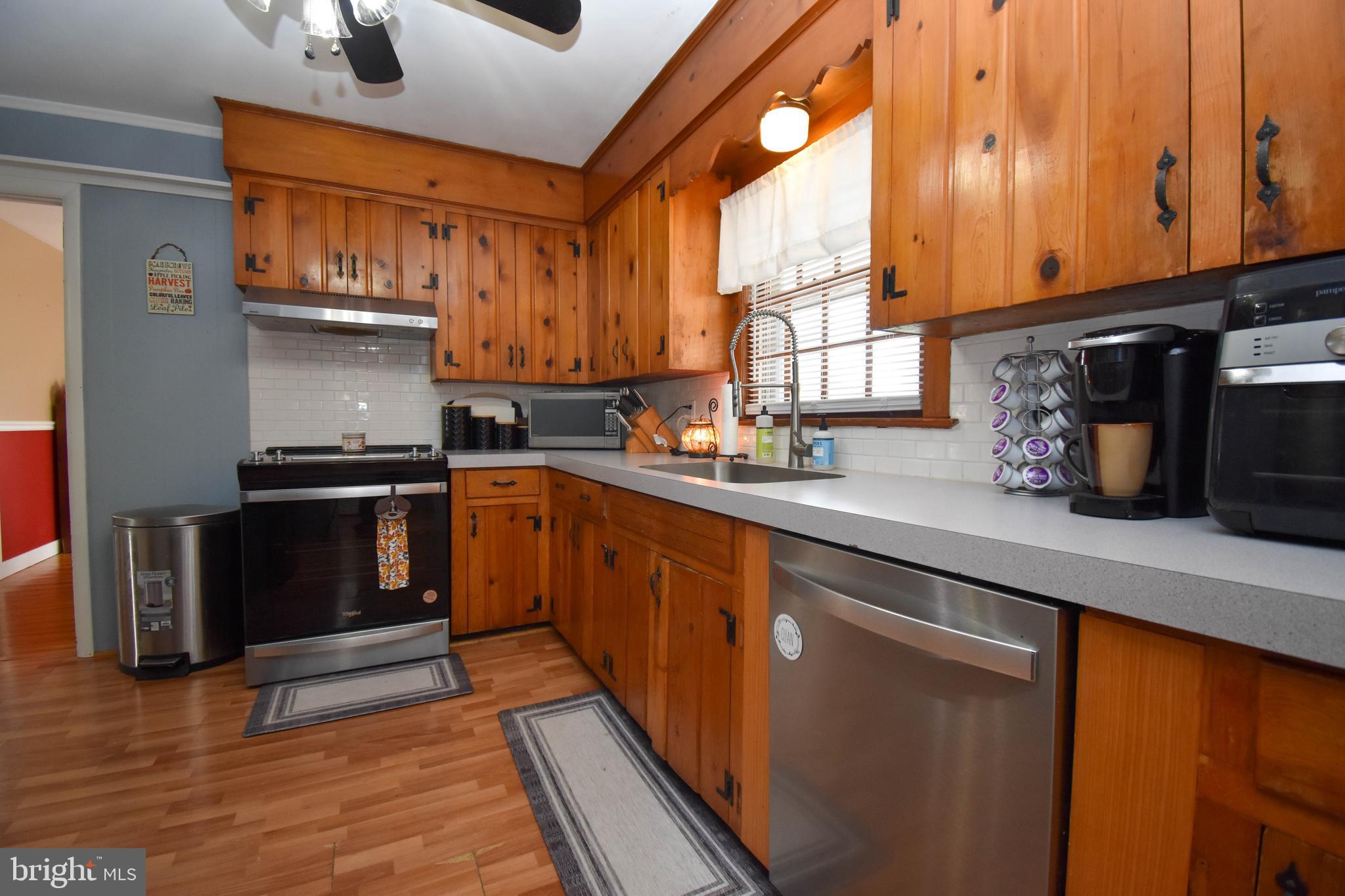 309 Robinson Street Georgetown, DE 19947 - Photo 10 of 26 a kitchen with stainless steel appliances granite countertop a stove a sink and a microwave