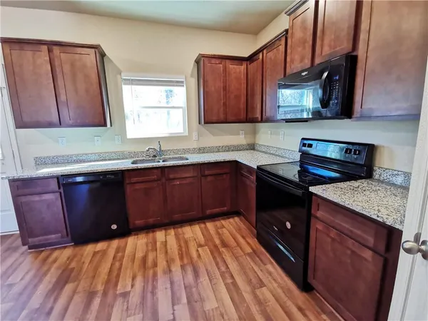 a kitchen with a sink a stove and cabinets