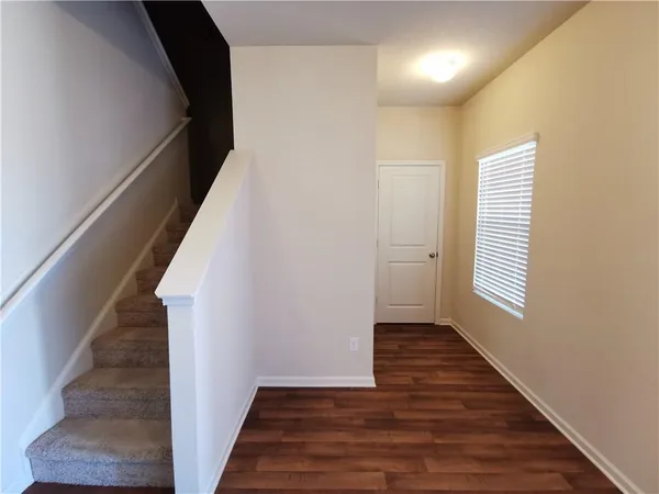 a view of a hallway with wooden floor and staircase