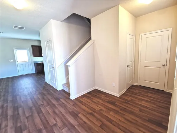 a view of a hallway with wooden floor and staircase