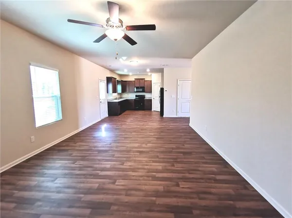 a view of a kitchen with wooden floor and a ceiling fan
