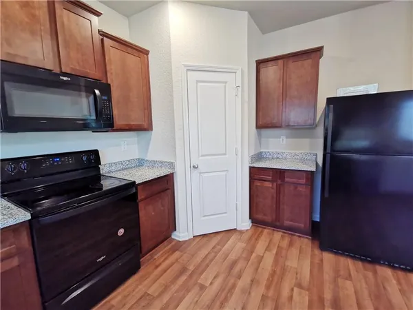 a kitchen with granite countertop wooden cabinets and stainless steel appliances
