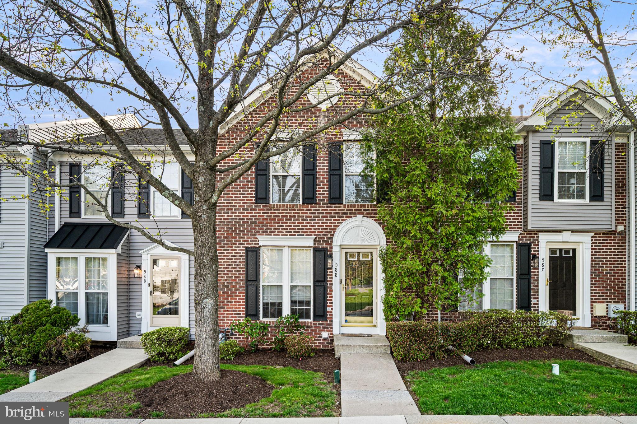 a front view of a house with yard and green space