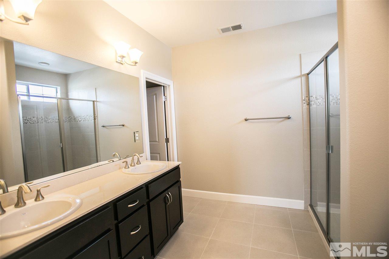 1856 Sea Horse Road, Unit A Reno, NV 89521 - Photo 14 of 16 a bathroom with a double vanity sink a mirror and a shower