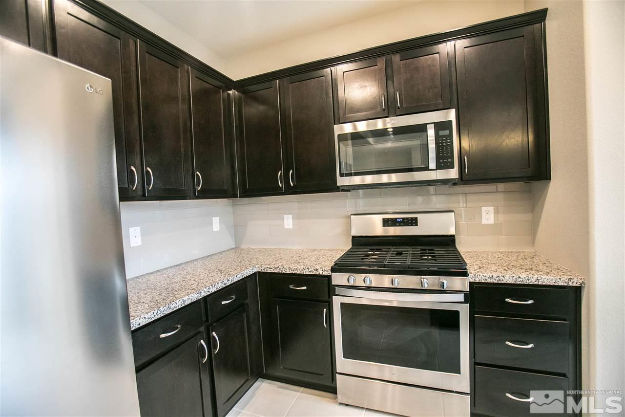 1856 Sea Horse Road, Unit A Reno, NV 89521 - Photo 7 of 16 a kitchen with granite countertop cabinets stove and microwave