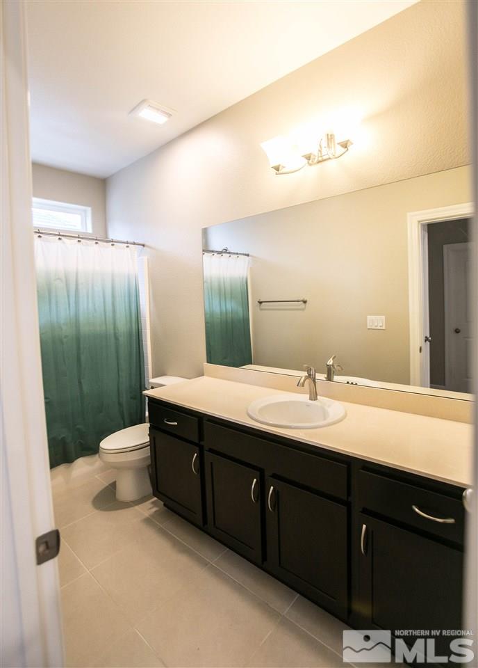 1856 Sea Horse Road, Unit A Reno, NV 89521 - Photo 10 of 16 a bathroom with a double vanity sink a toilet and a mirror