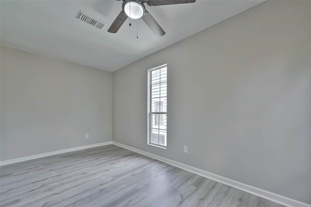 17805 Villa Way Drive Spring, TX 77379 - Photo 34 of 50 an empty room with wooden floor chandelier fan and windows