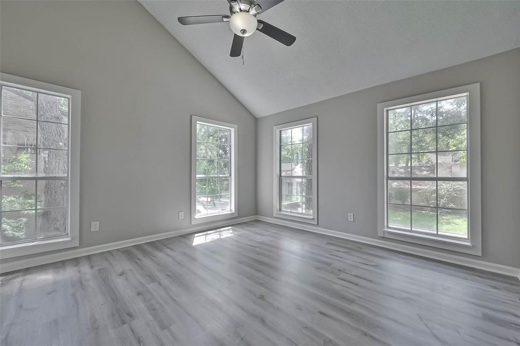 17805 Villa Way Drive Spring, TX 77379 - Photo 42 of 50 an empty room with wooden floor chandelier fan and windows
