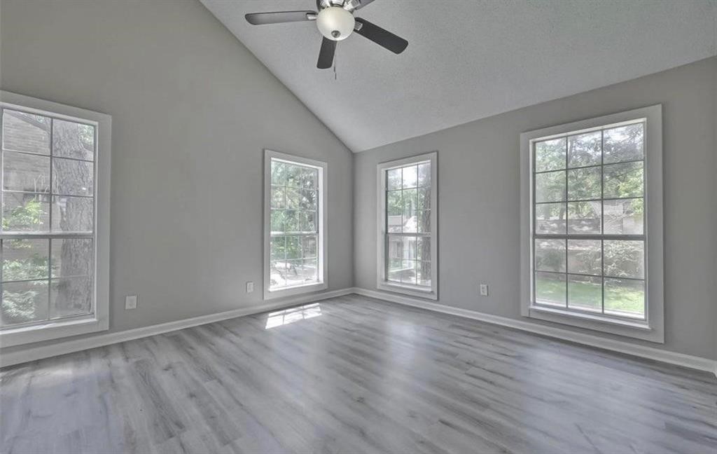 17805 Villa Way Drive Spring, TX 77379 - Photo 10 of 50 an empty room with wooden floor chandelier fan and windows