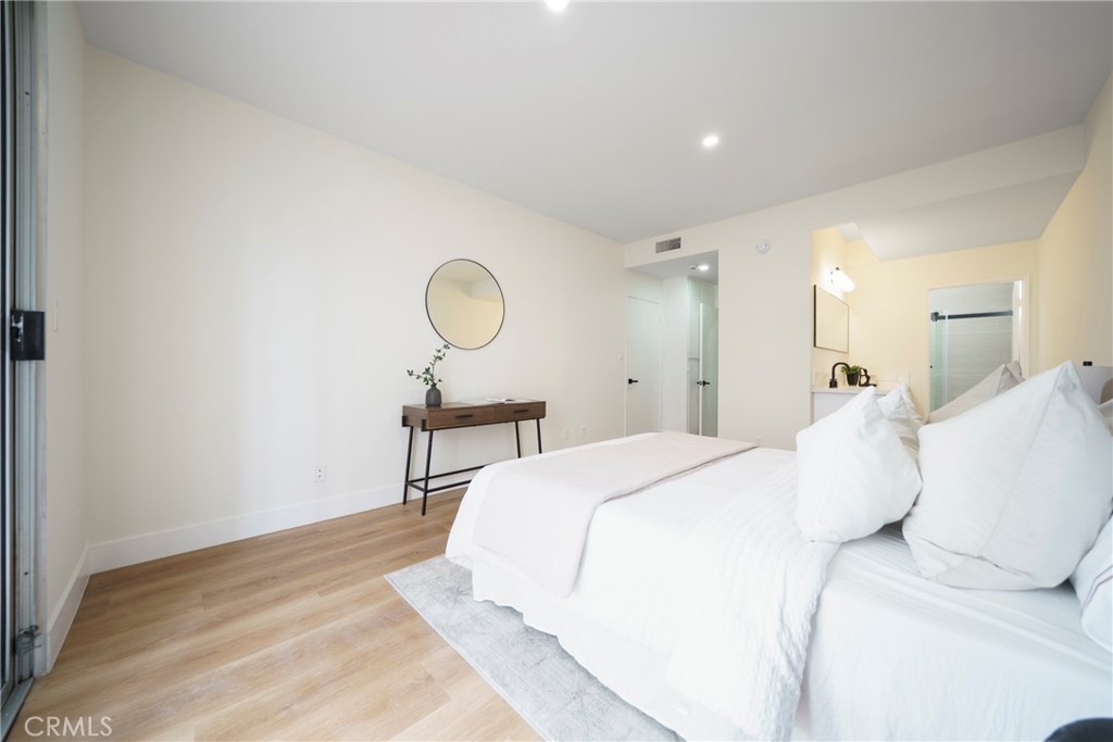 104 South Hayworth Avenue, Unit 204 Los Angeles, CA 90048 - Photo 16 of 52 a bedroom with a bed and a chandelier