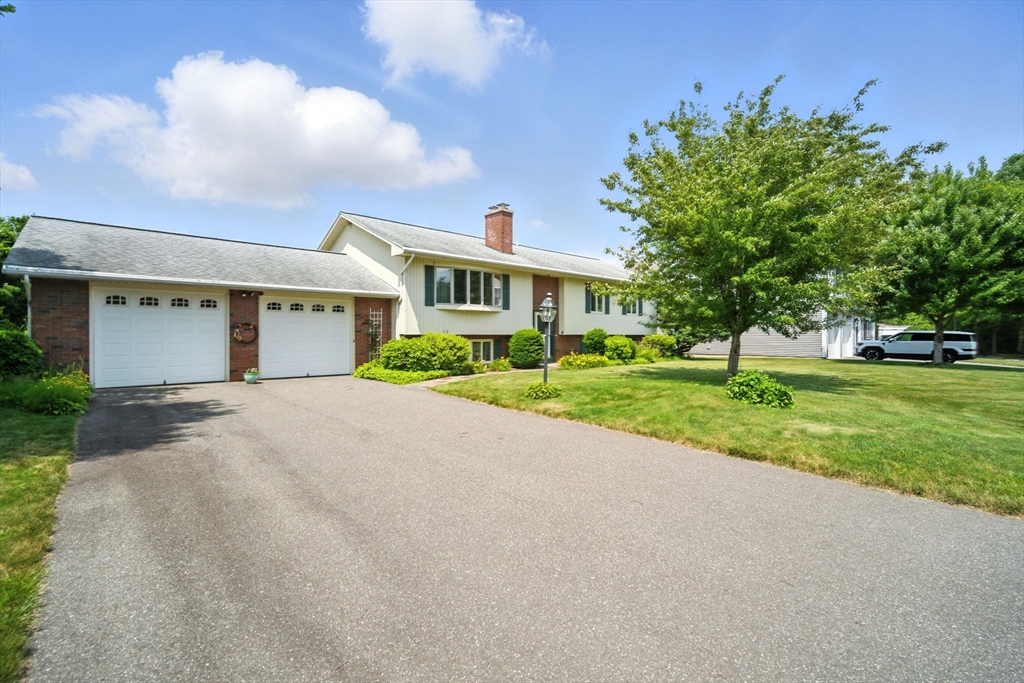 a front view of a house with a yard and trees