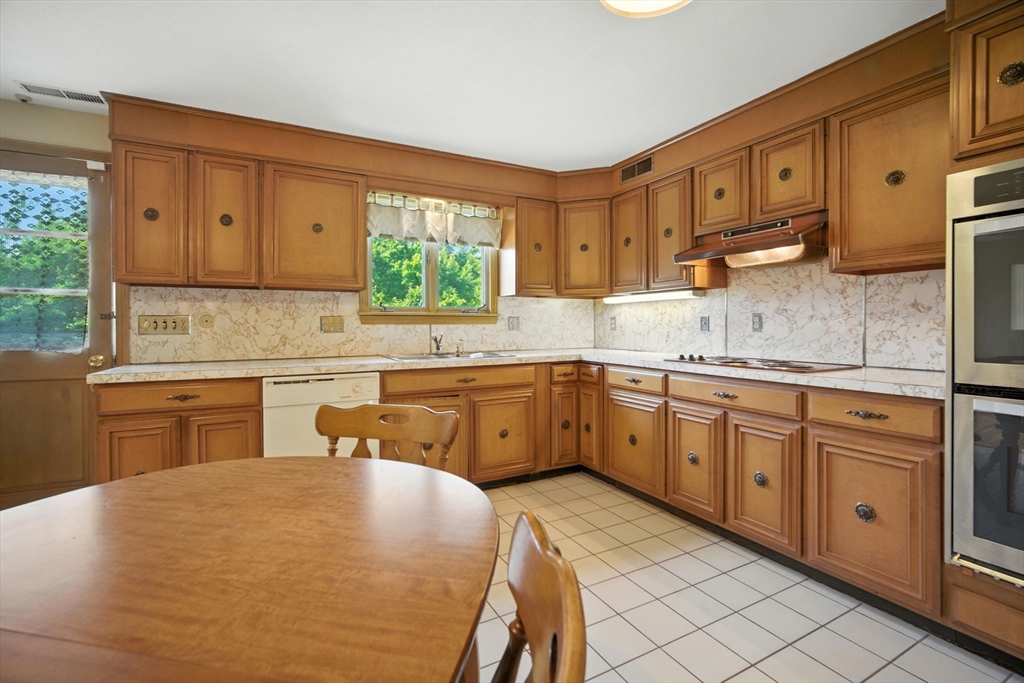 22 Woodland Road Springfield, MA 01129 - Photo 7 of 36 a kitchen with stainless steel appliances granite countertop a sink a stove a refrigerator with white cabinets and wooden floor