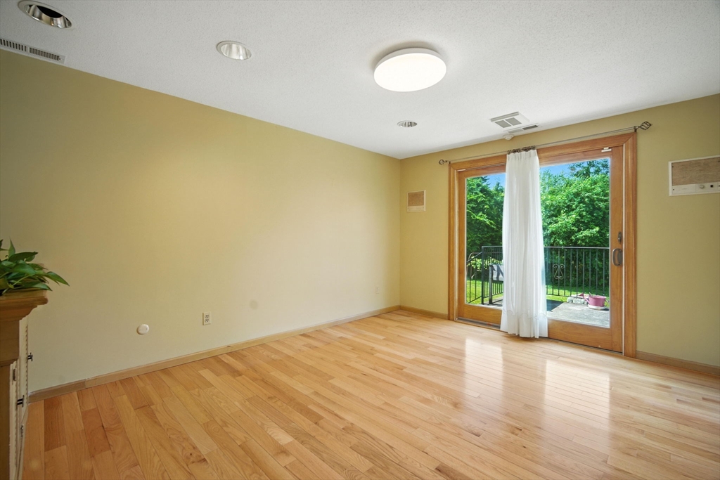 22 Woodland Road Springfield, MA 01129 - Photo 10 of 36 a view of an empty room with a window and wooden floor