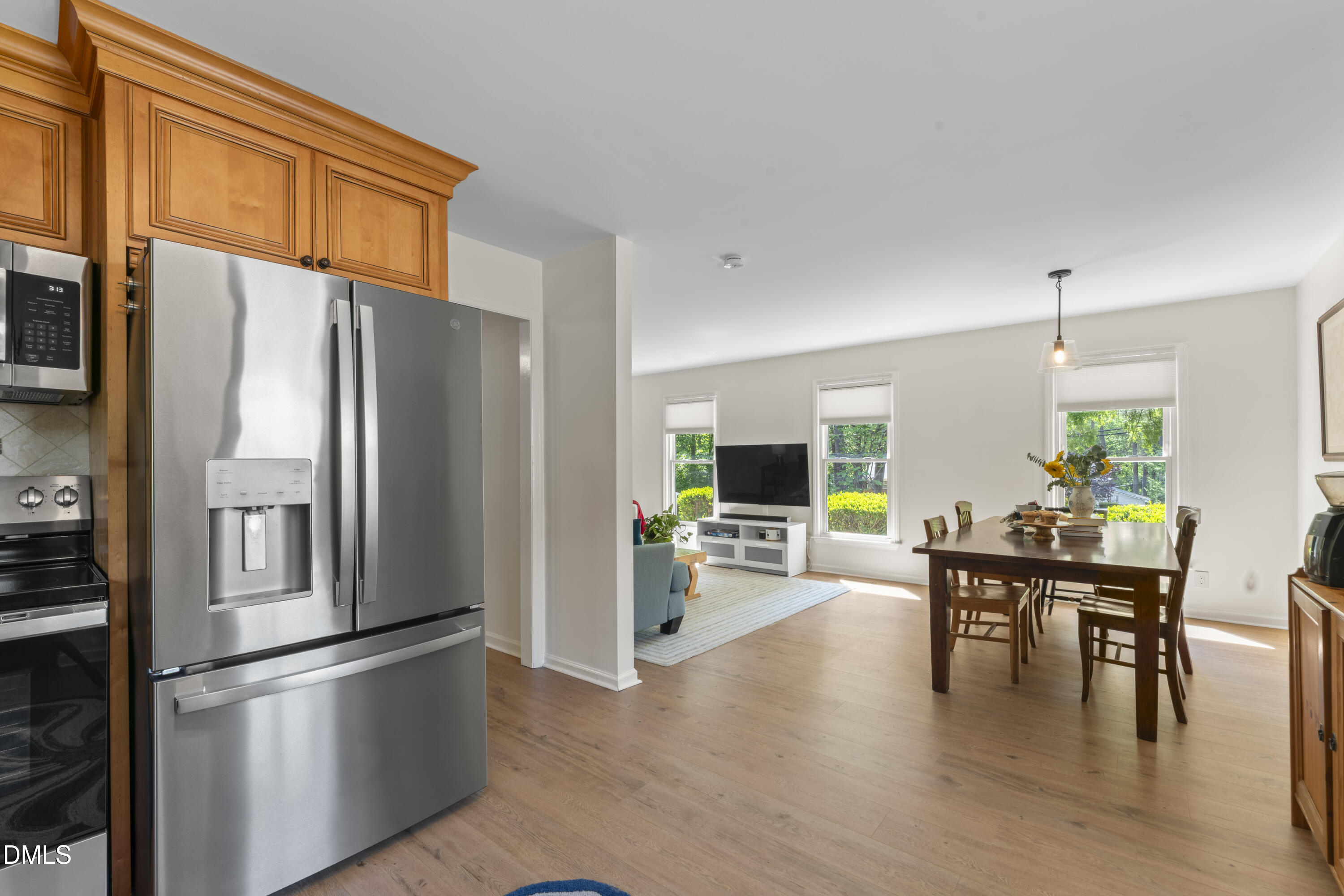 3419 Old Chapel Hill Road Durham, NC 27707 - Photo 14 of 38 a kitchen with stainless steel appliances granite countertop a refrigerator a stove a dining table and chairs with wooden floor