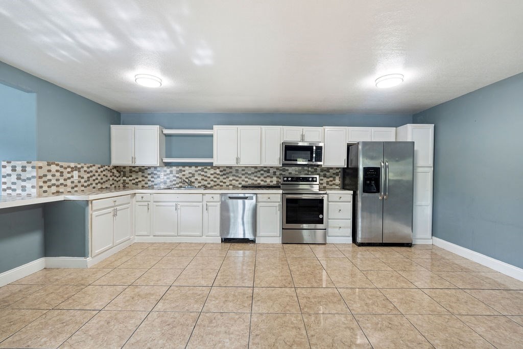 2915 Freeman Street Lufkin, TX 75901 - Photo 19 of 31 a kitchen with stainless steel appliances a refrigerator sink stove and cabinets