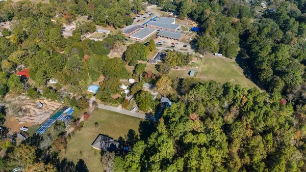 an aerial view of residential house with parking and yard