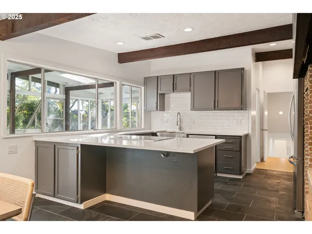 a kitchen with a sink stainless steel appliances cabinets and a counter top space