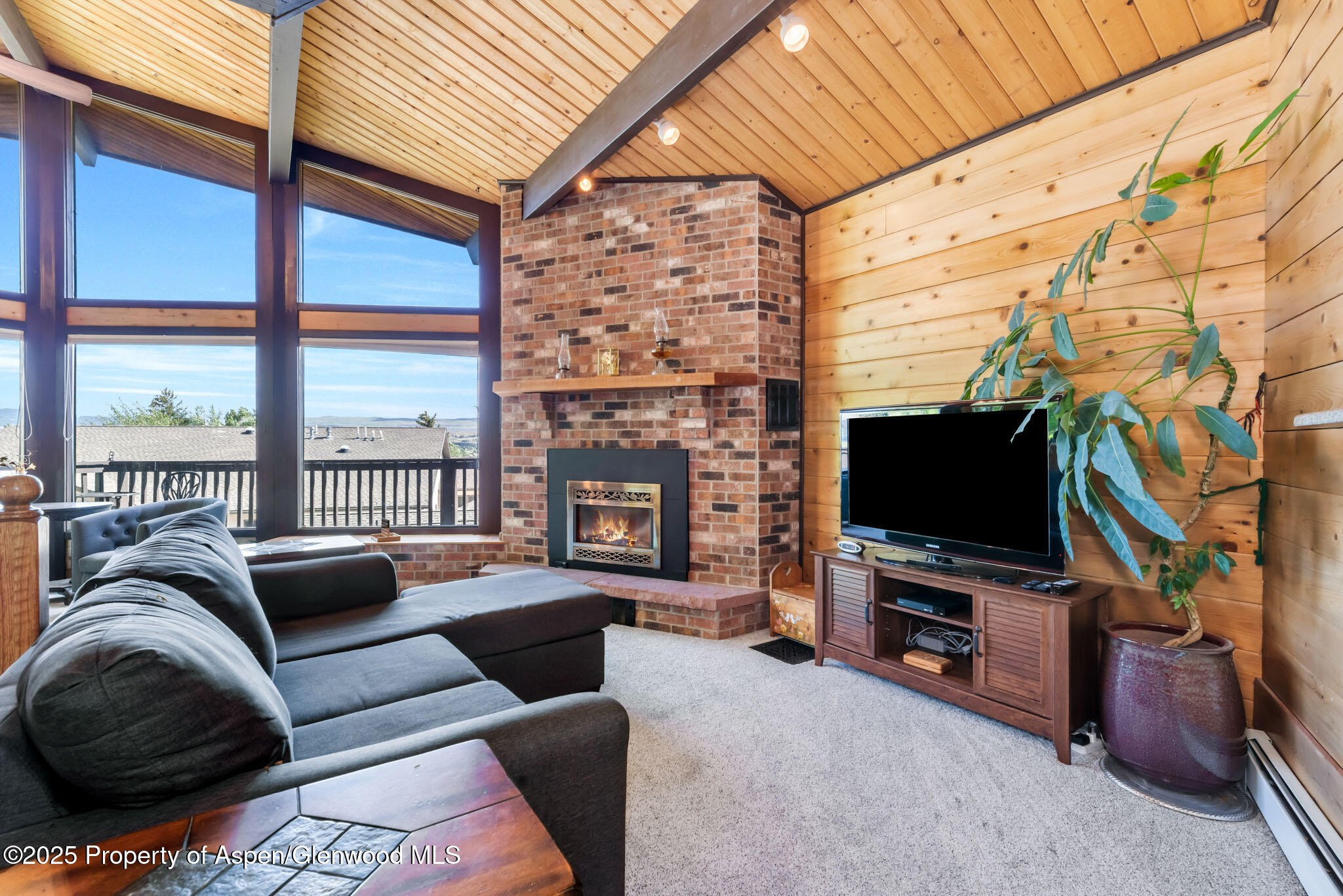 922 Steele Court Craig, CO 81625 - Photo 15 of 115 a living room with furniture a flat screen tv and a floor to ceiling window