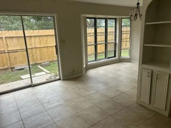 a view of an empty room and window a ceiling fan