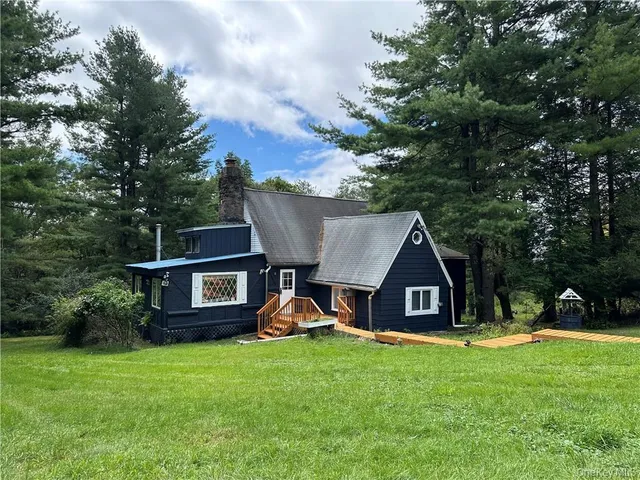 a view of a house with a yard and sitting area