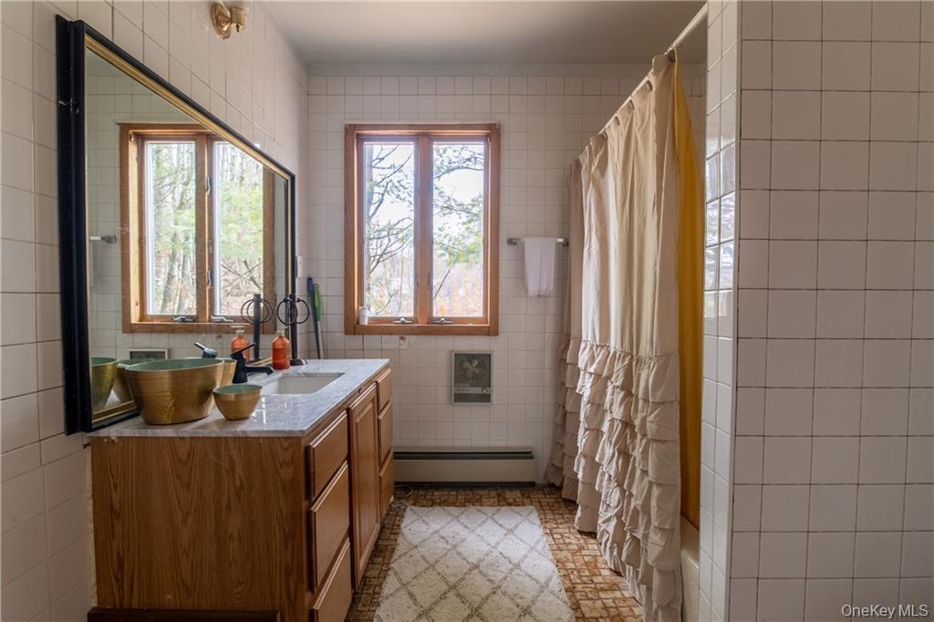 71 Kawlija Road Grahamsville, NY 12740 - Photo 12 of 16 a bathroom with a sink a mirror and a bathtub