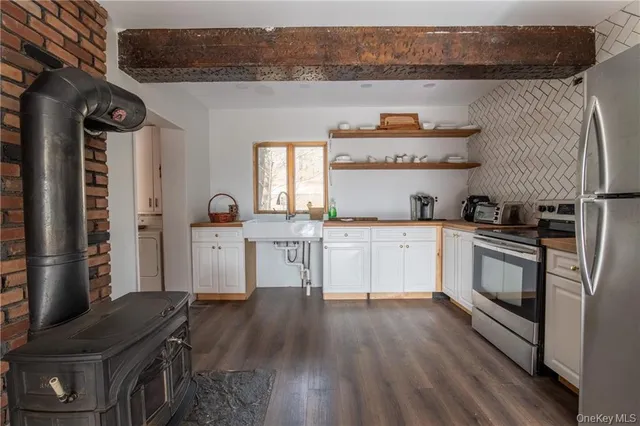 a kitchen with granite countertop a sink cabinets and stainless steel appliances