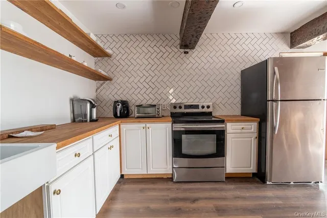 a kitchen with stainless steel appliances a refrigerator sink and stove top oven