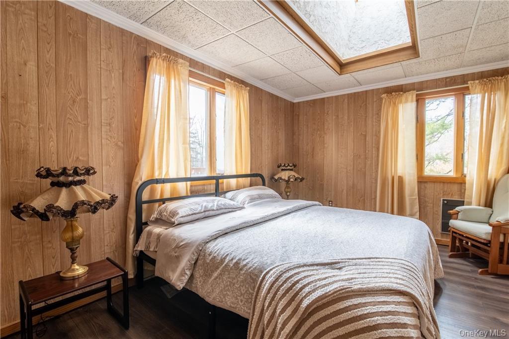 71 Kawlija Road Grahamsville, NY 12740 - Photo 10 of 16 a bedroom with a bed and a chandelier