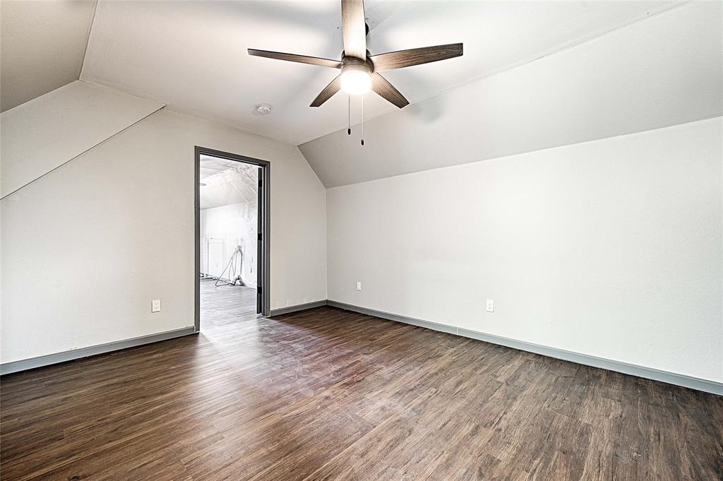 4805 Hunters Ridge Drive Sachse, TX 75048 - Photo 12 of 24 an empty room with wooden floor chandelier fan and windows