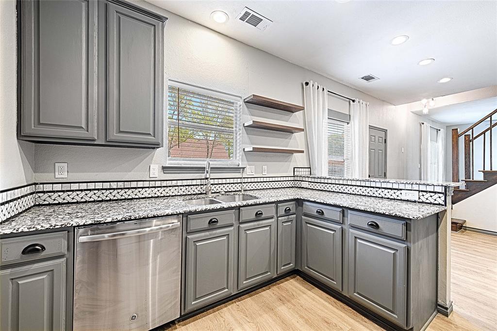 4805 Hunters Ridge Drive Sachse, TX 75048 - Photo 3 of 24 a kitchen with granite countertop a sink stove and cabinets