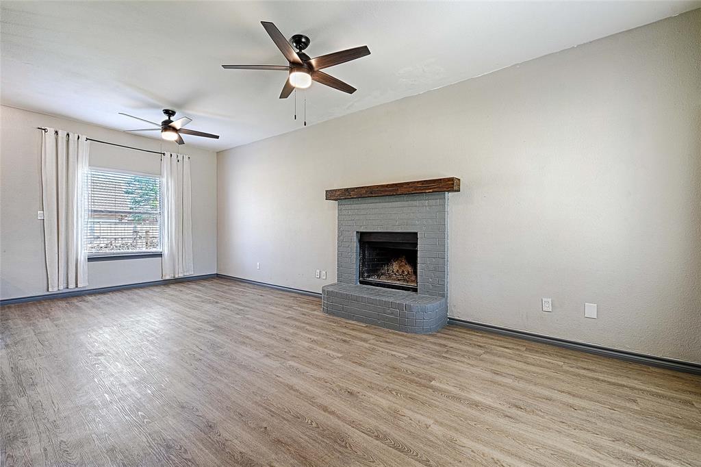 4805 Hunters Ridge Drive Sachse, TX 75048 - Photo 6 of 24 an empty room with windows and fireplace