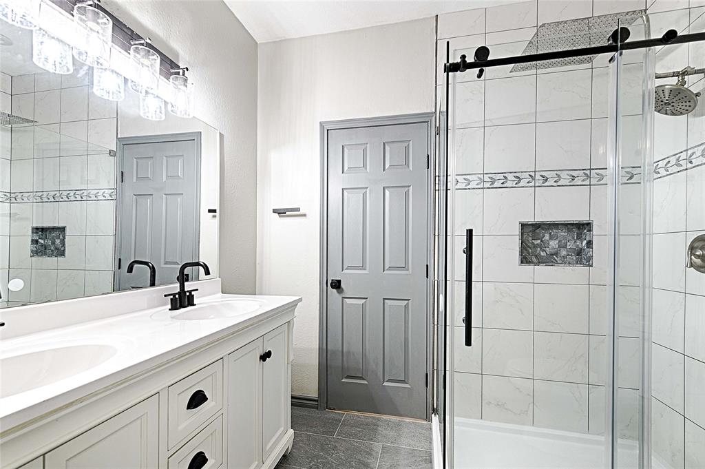 4805 Hunters Ridge Drive Sachse, TX 75048 - Photo 7 of 24 a bathroom with a sink a mirror and shower