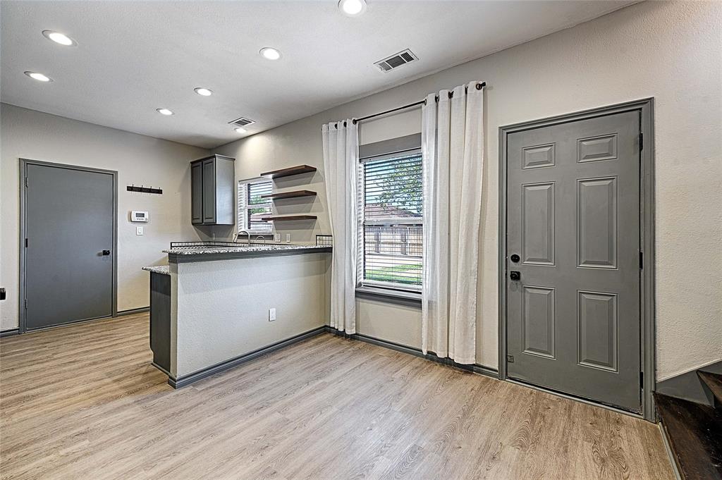 4805 Hunters Ridge Drive Sachse, TX 75048 - Photo 9 of 24 a kitchen with stainless steel appliances granite countertop a stove a sink and a refrigerator with wooden floors