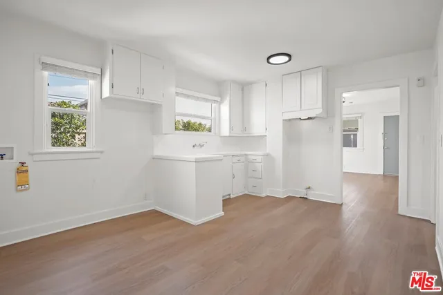 a room with a white cabinets and wooden floor