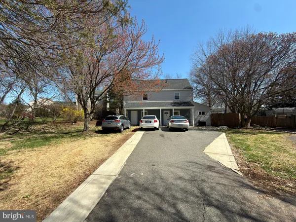 a view of a white house with a yard covered in snow