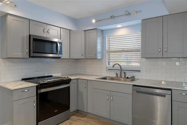 a kitchen with a sink stove and microwave
