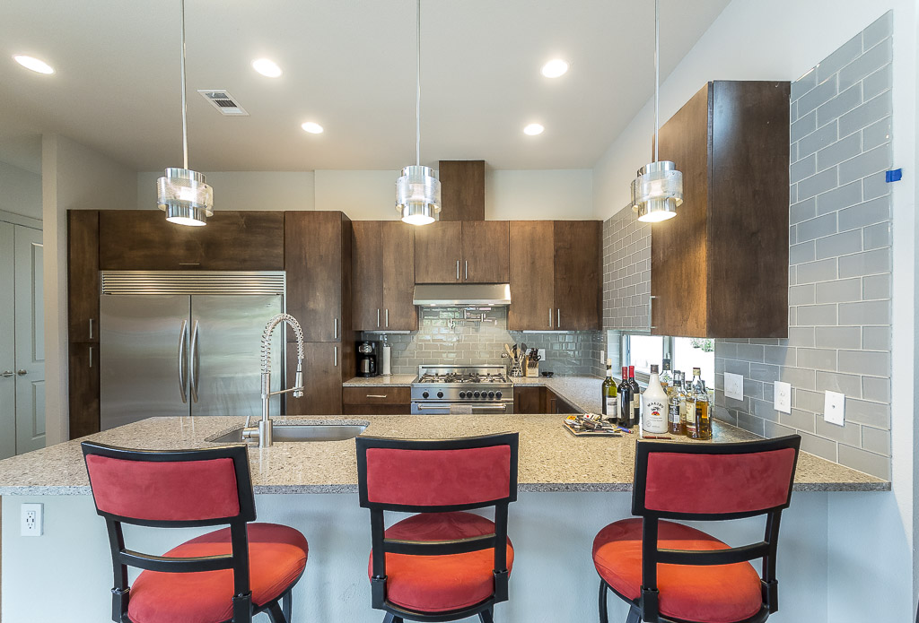 2501 East 9th Street Austin, TX 78702 - Photo 8 of 38 a kitchen with stainless steel appliances kitchen island granite countertop a kitchen island and chairs