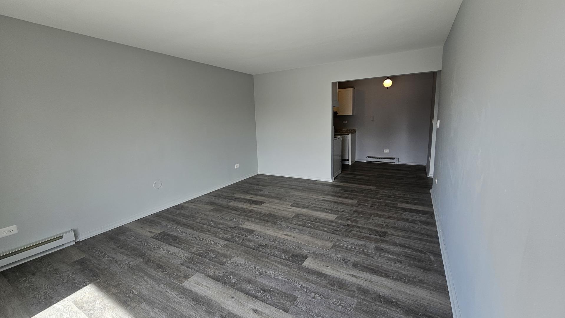 850 East Old Willow Road, Unit 218 Prospect Heights, IL 60070 - Photo 2 of 6 a view of an empty room with wooden floor and a window